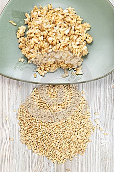 Pile of raw whole oat grains and boiled porridge