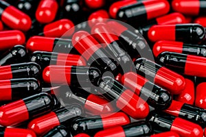 Pile of red-black capsule pills. Antibiotics resistance. Drug use with reasonable. Global healthcare concept. Antibiotics drug photo