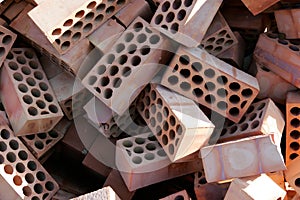 Pile of red bricks with cirlces or holes