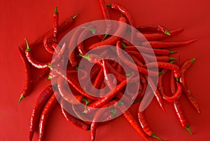 a pile of red chili peppers on a red popy background