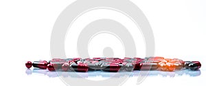 Pile of red and grey capsule pills isolated on white background with copy space. Flunarizine : drug for migraine prophylaxis