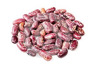 Pile of red spotted pinto beans closeup on white