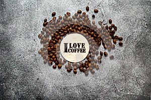 Pile of roasted coffee beans with `I love coffee` wooden stencil