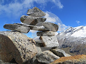 Pile of rocks balancing high up in the mountains, summit, mountain cairn, journey, path,
