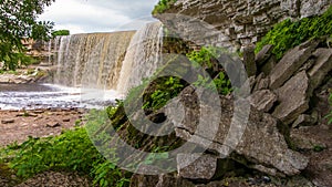 Pile of rocks in the foreground and a waterfall on the background