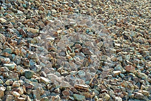 Pile of rocks and pebles used for background and texture purposes in late afternoon sun with multicolor pattern