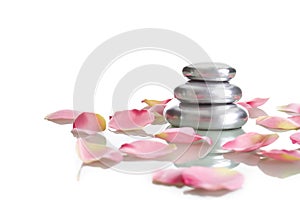 Pile of round pebble stone with rose petals