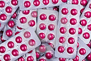 Pile of round pink tablets pill in blister pack. Pharmaceutical industry. Pharmacy products. Prescription drug. Painkiller