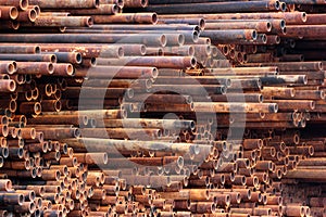 Pile of rusty metal pipes as industrial background