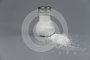 A pile of salt from salt shaker, concept excessive salt intake