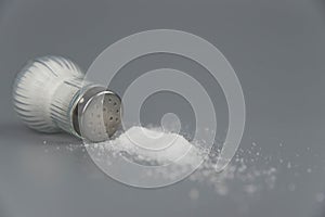 A pile of salt from salt shaker, concept excessive salt intake