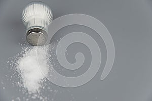 A pile of salt from salt shaker, concept excessive salt intake