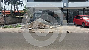 pile of sand and gravel in front of the shophouse