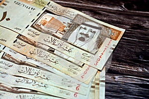 Pile of Saudi Arabia 10 SAR ten Saudi riyals cash money banknote with the photo of king Abdullah Bin AbdulAziz Al Saud and Murabba