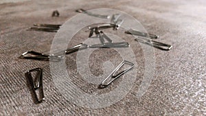 Pile of scattered silver paperclip on a stone wood background