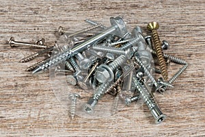 Pile of Screws on Wooden Background