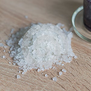 Pile of sea salt on wooden table. Natural ingredient for spa and exfoliation