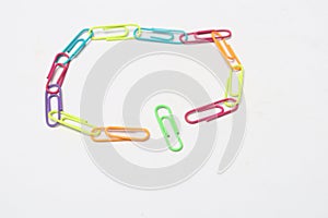 A pile of several colorful paper clips. A tool for clamping and joining multiple sheets of paper or files.