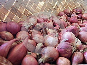 A pile of shallots in a traditional wicker container