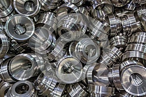 Pile of shiny metal aerospace parts production - close-up with selective focus for full frame industrial background