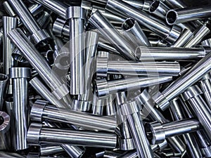 pile of shiny steel tubes after cnc turning operations - abstract full frame indistrial background
