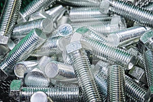 A pile of silver bolts. Stainless steel bolts, close-up. Construction fixture. Fasteners made of steel
