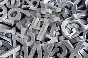 Pile of silver metal alphabet characters cutted by waterjet machine photo
