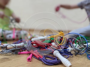 Two children untangling knotted skipping ropes