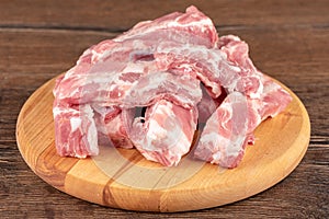 Pile sliced raw pork ribs round on cutting board.