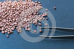 pile of small bronze pieces displayed on dark background