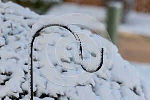 A pile of snow onto of a hook in a garden