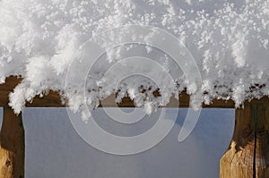 Pile of snow on a wooden railing Abstract and closeup.