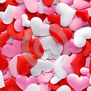 Pile of soft red, pink, and white cloth hearts for romantic or Valentine`s Day background