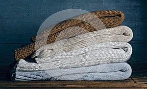Pile stack folded of knitted warm clothes on wooden background, sweaters, knitwear