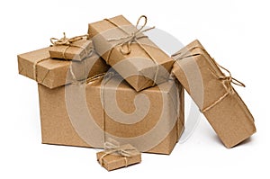 Pile of stacked boxes wrapped with brown kraft paper and tied with twine on a white background. Delivery, moving concept