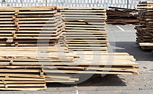 Pile of stacked wooden planks at a construction site. Wooden boards, lumber. Industrial edged timber. Wooden rafters for