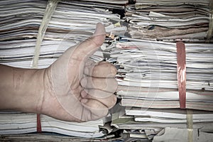 pile or stacks of old papers for recycling with hand thump up. g