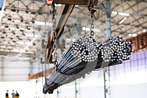 Pile of steel rods hanging on a metal structure at a manufacturing company