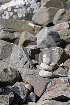 Pile of stones carefully arranged in a balanced stack atop a rocky surface