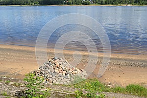 A pile of stones lies on the bank of river, symbolizing order, perfectionism, harmony