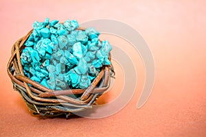 Pile stones of raw Turquoise in small wooden nest on a brown background