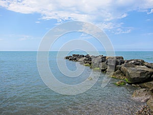 A pile of stones stretches out into the sea