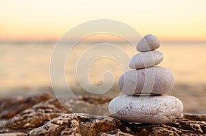 Pile of Stones on Tranquil Beach at Sunset