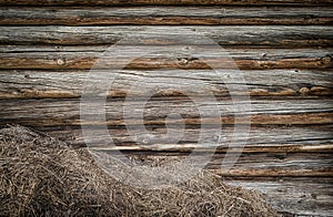 A pile of straw against a wooden wall. The old barn wall. Rustic background with a place to record