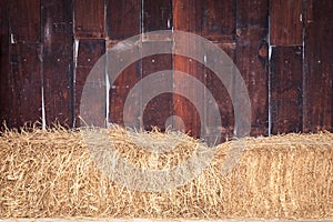 Pile of straw infront of wooden wall