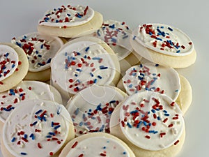 Pile of sugar cookies with white frosting covered in red, white and blue sprinkles for the 4th of July, Memorial Day, Veteranâ€™s