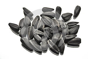 A pile of sunflower seeds lie on a white background