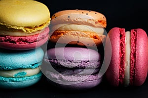 Pile of sweet colourful macaroons on black