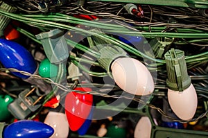 Pile of tangled large bulb Christmas lights with green wire