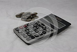 A pile of Thai bath coins and calculator on the white background. a flat, used as money, calculator.